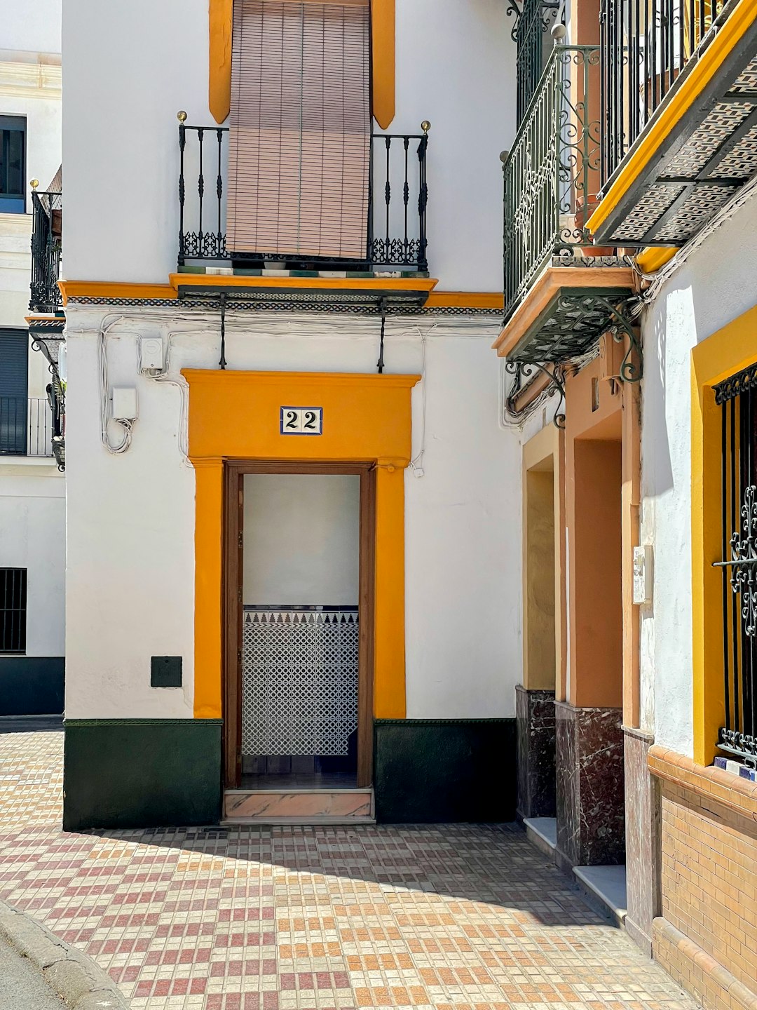 a-yellow-and-white-building-with-a-brown-door-3kveoeqcgyq